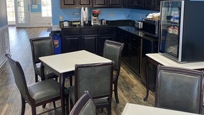 Een restaurant met donkere houten kasten, een witte tafel en stoelen.