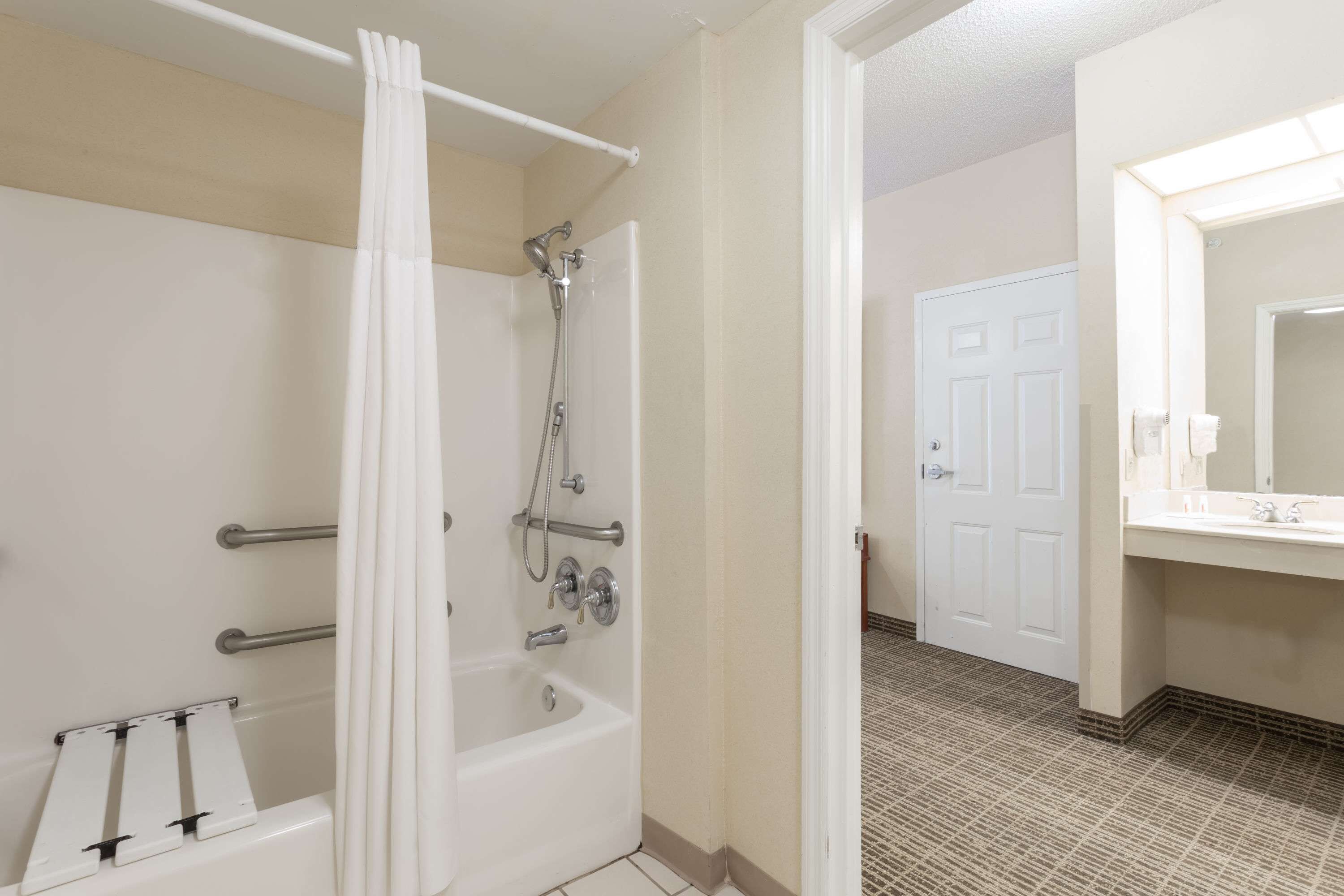 Un baño con ducha, bañera y lavamanos.