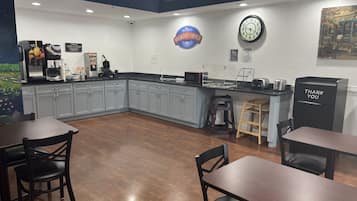 Cocina moderna con armarios grises, una estación de café, un reloj y un letrero que dice 'Breakfast Corner'.