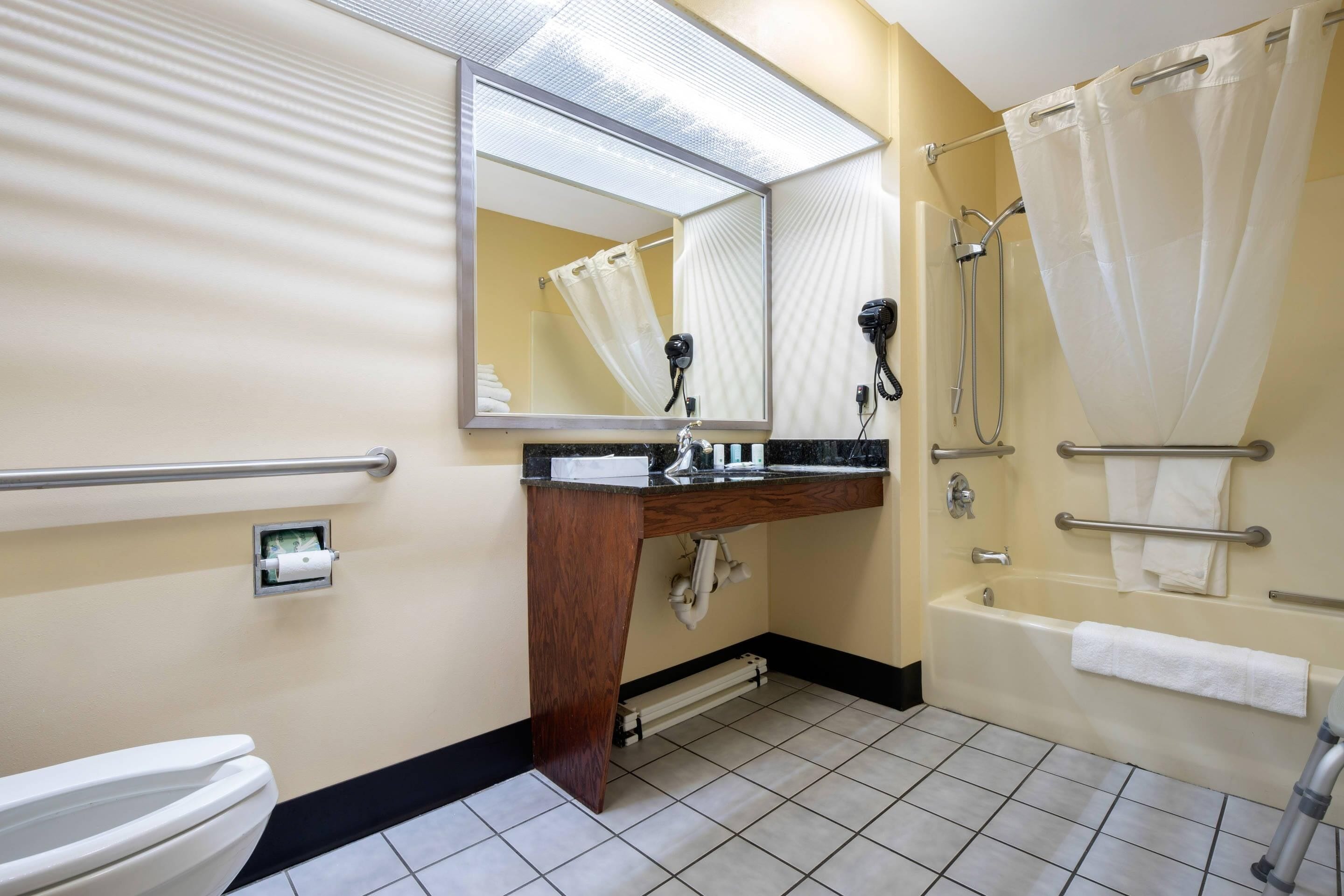 Un bagno con il water, lavandino, specchio, doccia e vasca.
