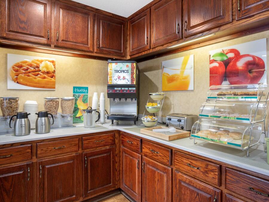 A breakfast bar with waffle display, coffee station, and fruit display.