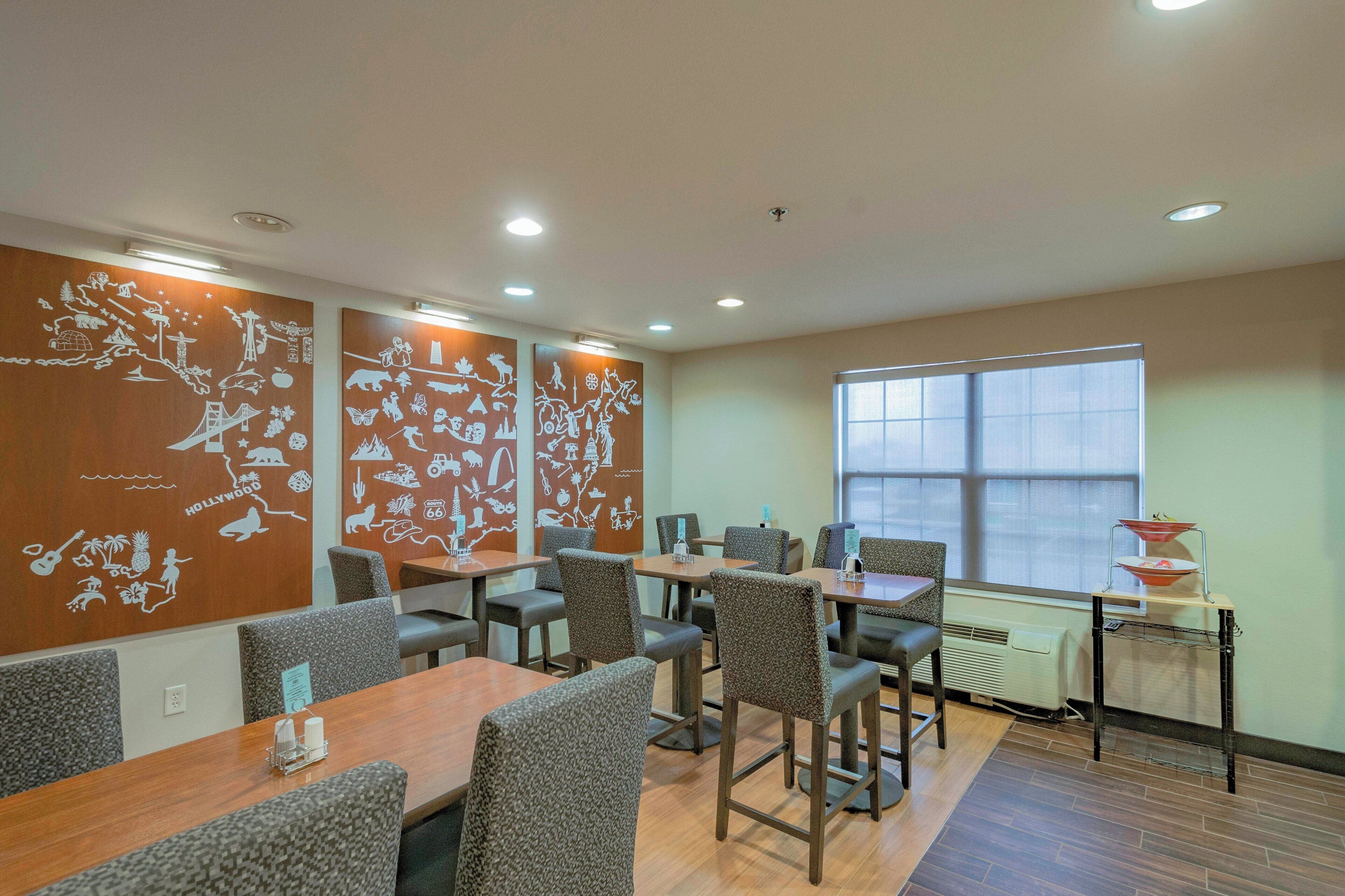 A conference room with a long table, multiple chairs, and decorative wall art.