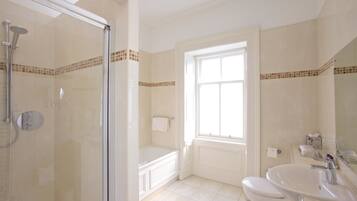 Une salle de bain avec une douche à parois de verre, une baignoire, des toilettes et un lavabo.
