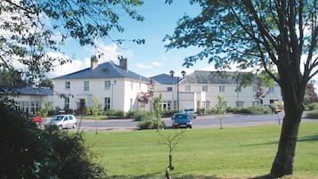 Un quartier résidentiel avec des maisons, une pelouse verdoyante et des voitures garées.