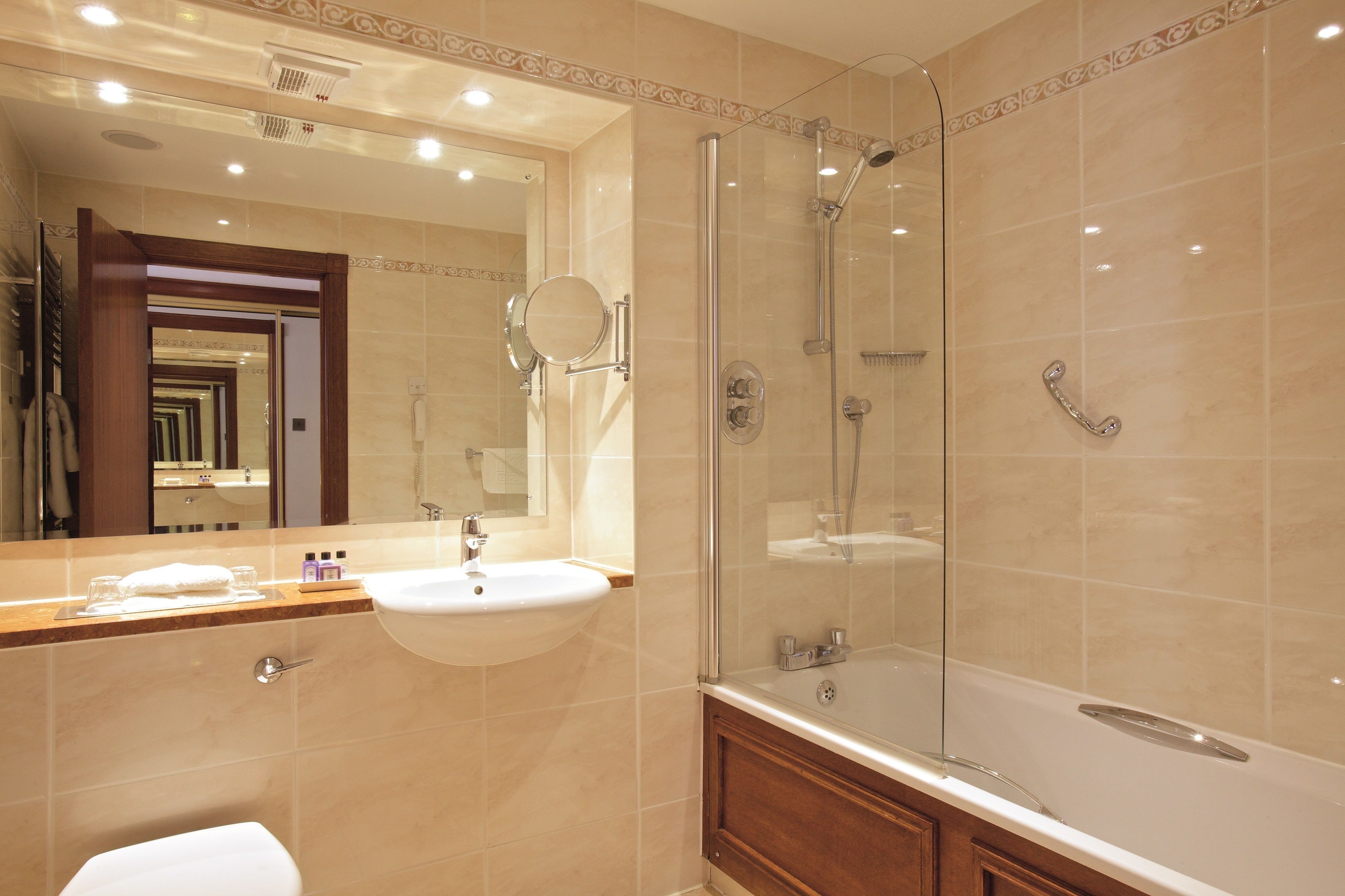 Une salle de bain moderne avec une douche à parois de verre, un meuble-lavabo à deux vasques et un grand miroir.