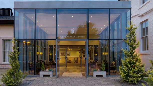 A modern building with a glass facade and the name "CRUTHERLAND SUITE" visible above the entrance.