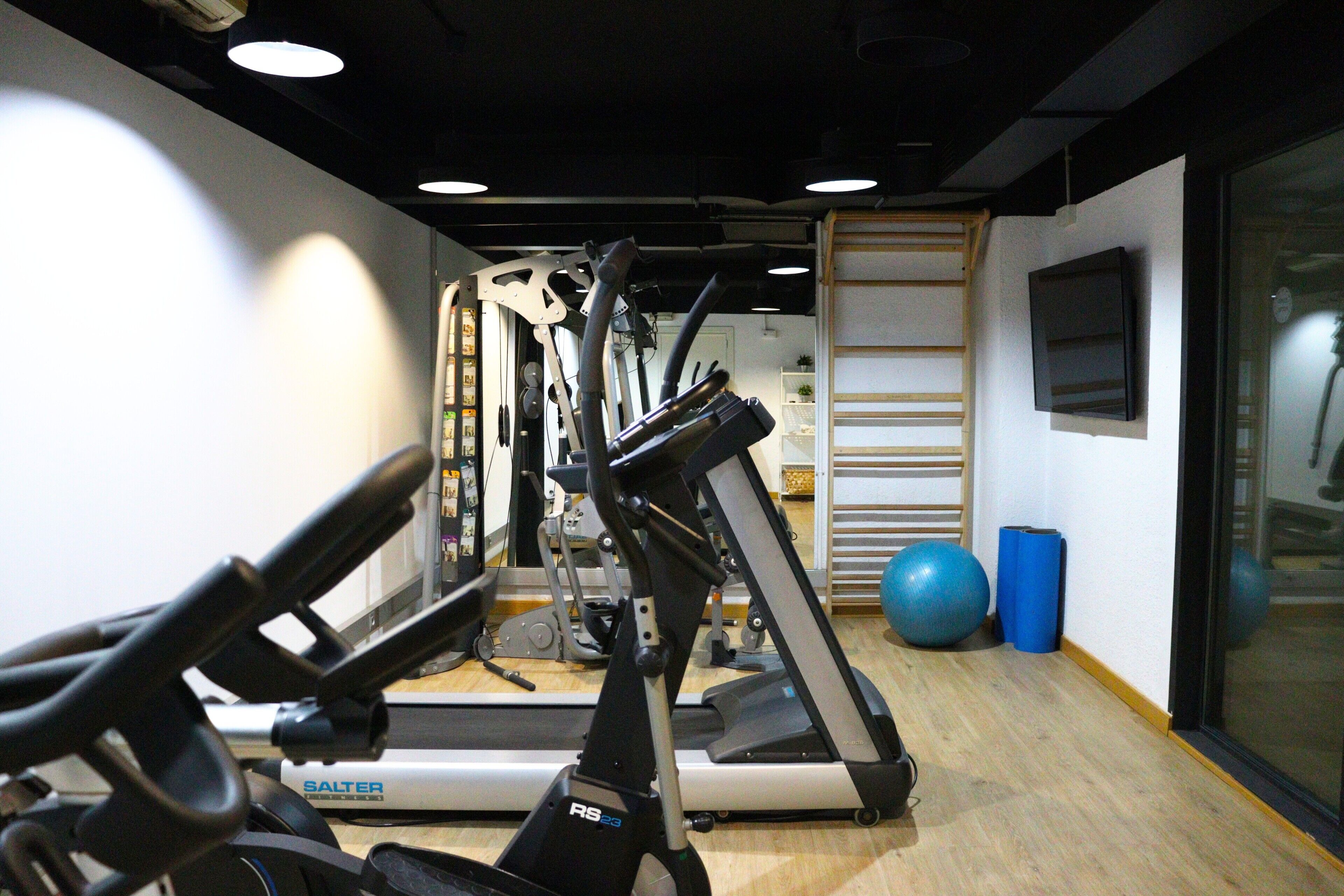 A gym with stationary bikes, treadmills, and exercise balls.