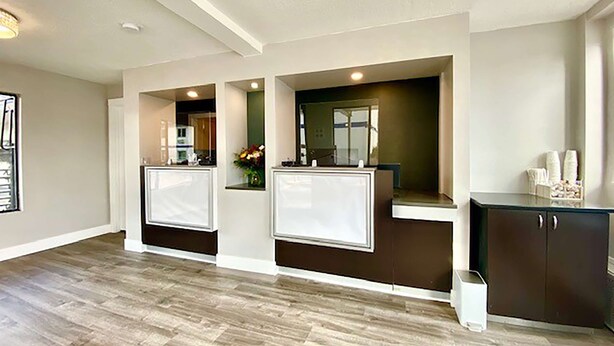 A modern kitchen with two islands, dark cabinetry, and recessed lighting. - Travelodge Inn & Suites by Wyndham Missoula University Park (Missoula)