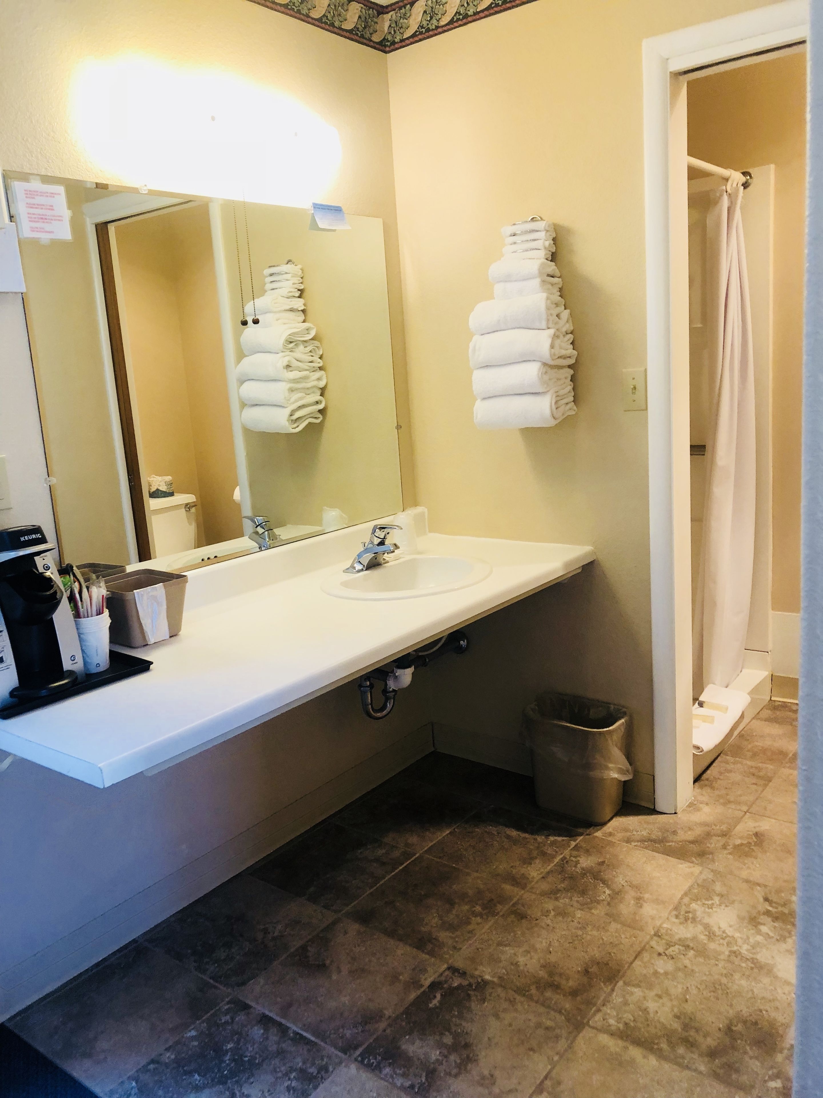 A bathroom with a white sink, a mirror, and a towel rack.