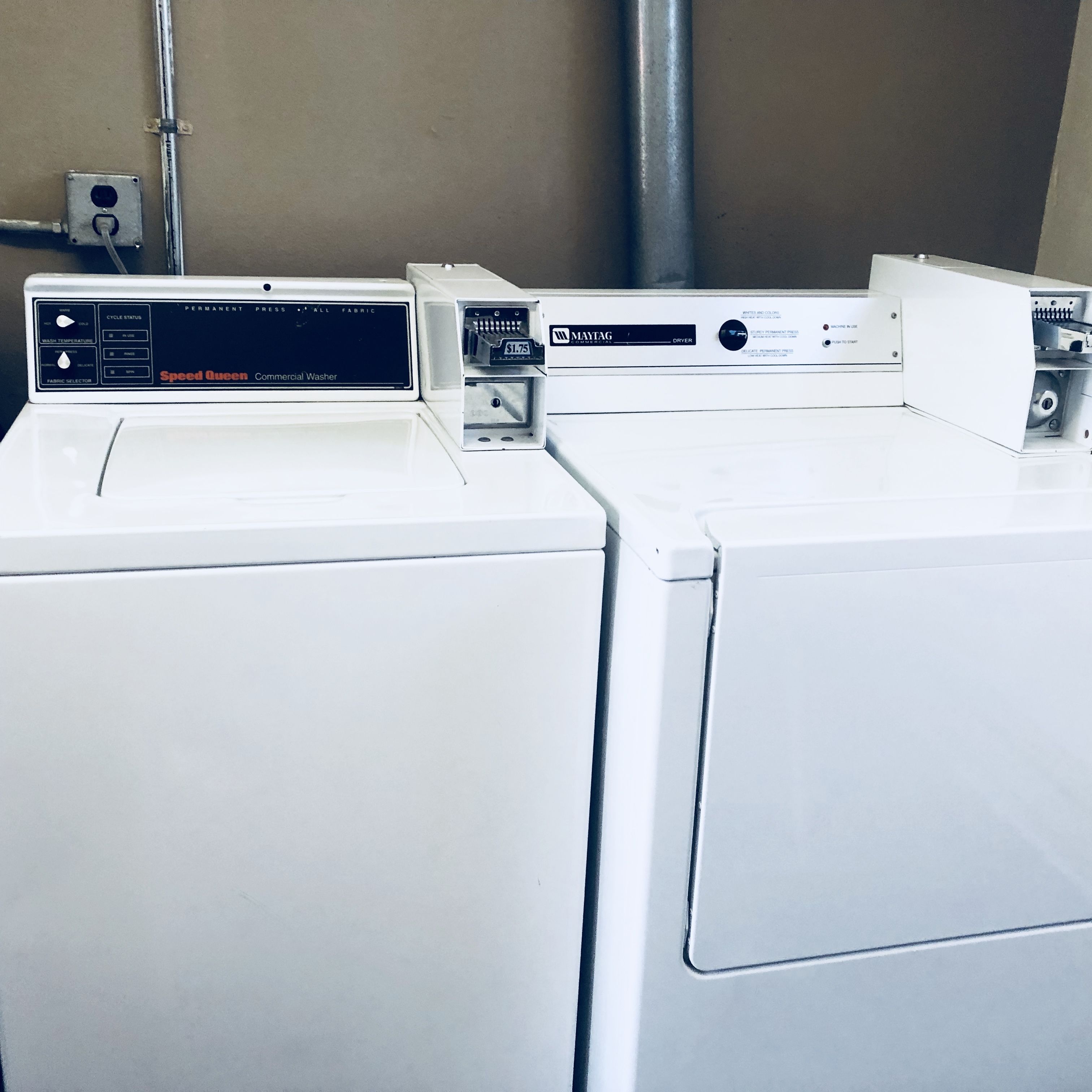 A row of commercial washers in a utility room.