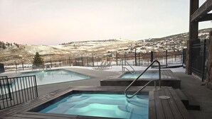 A hot tub area with a view of a snowy village.