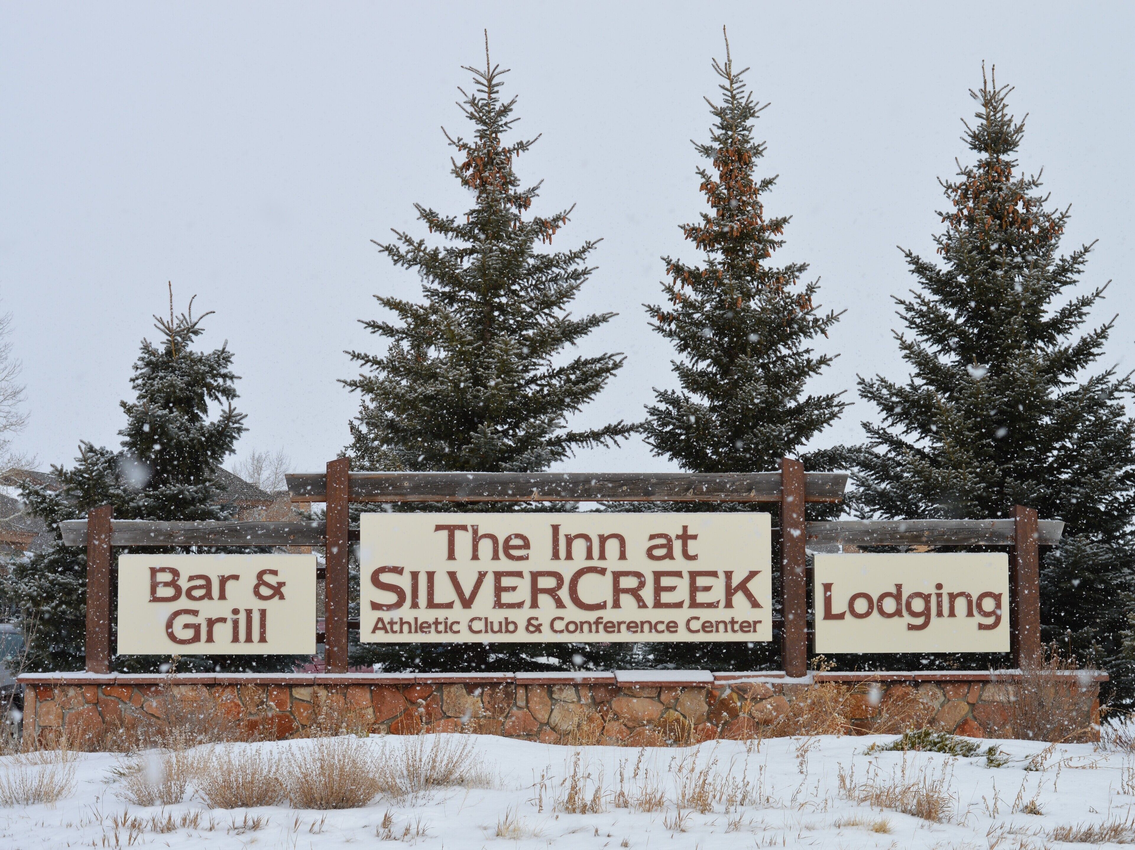 Une enseigne pour l’établissement The Inn at Silver Creek Athletic Club & Conference Center, avec des sections distinctes pour le bar-grill et l’hébergement.