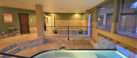 Un área de spa con un jacuzzi, una puerta de madera, un letrero y una ventana.