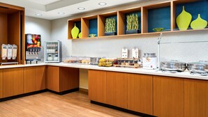 Een modern ontbijtbuffet met houten kastjes, een koelkast en diverse etenswaren.