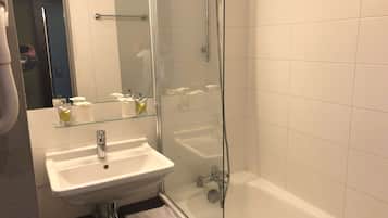 Un baño con cabina de ducha de vidrio, un lavamanos blanco y una bañera.