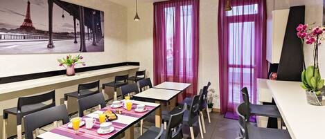 A dining area with tables, chairs, and a large painting of the Eiffel Tower.