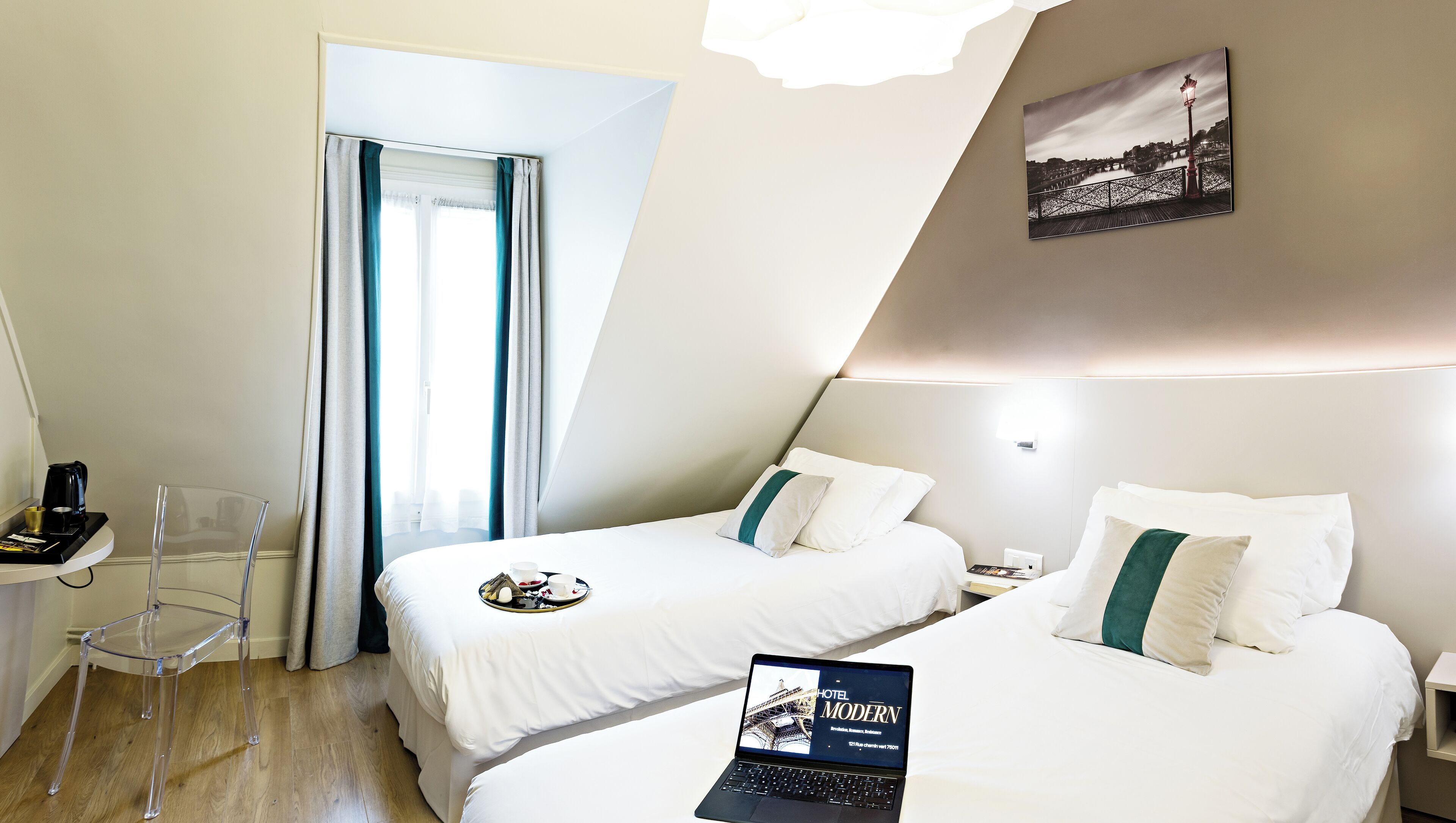 A hotel room with two beds, a desk, and a chair.