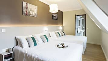 Une chambre d’hôtel avec deux lits, une table de chevet avec un téléphone, un plateau avec du thé et une peinture au mur.