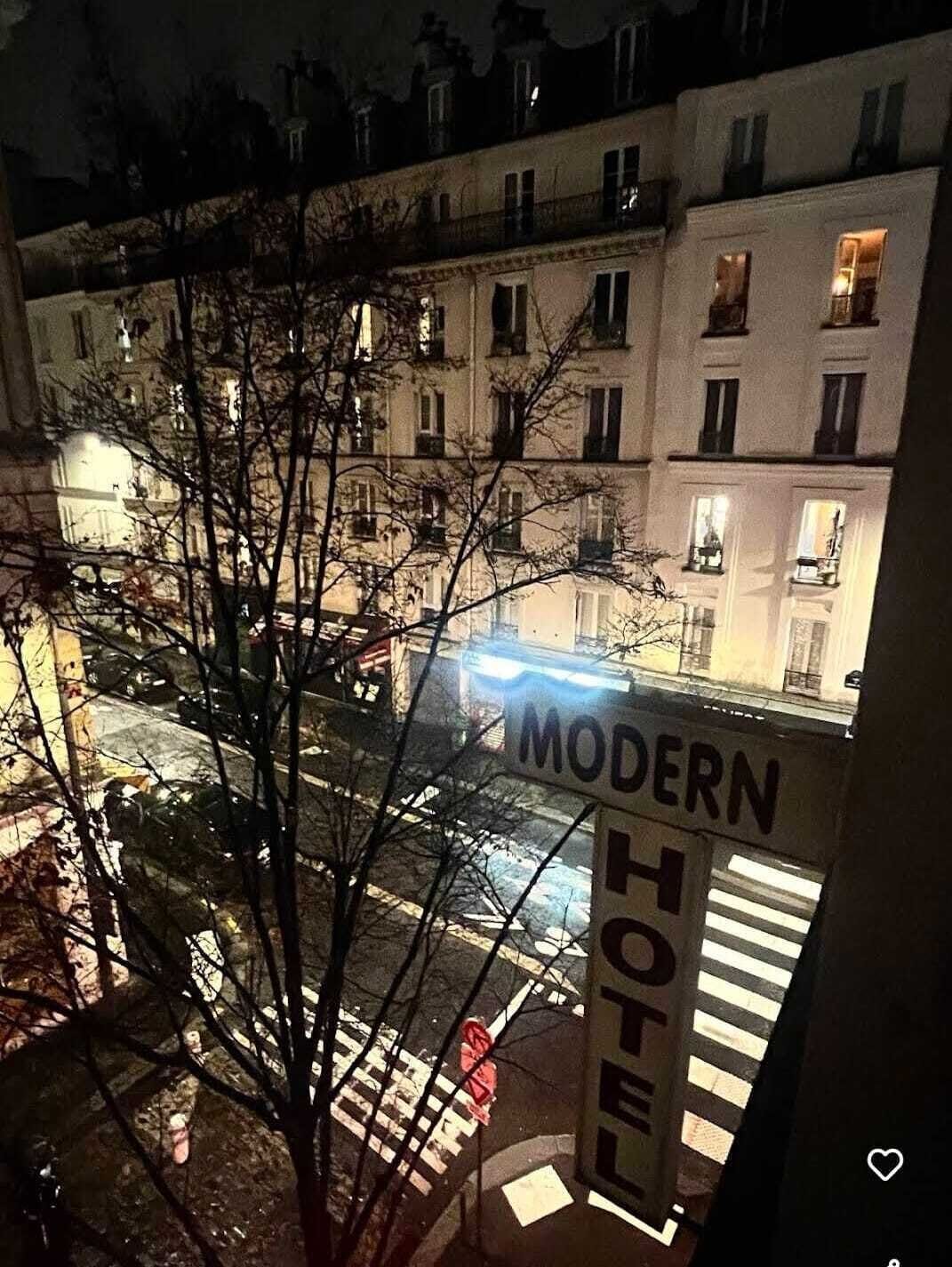 Vista de un edificio con un letrero que dice 'MODERN HOTEL' en primer plano.