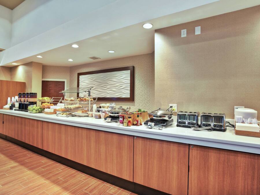 A buffet counter with various food items and kitchen appliances.