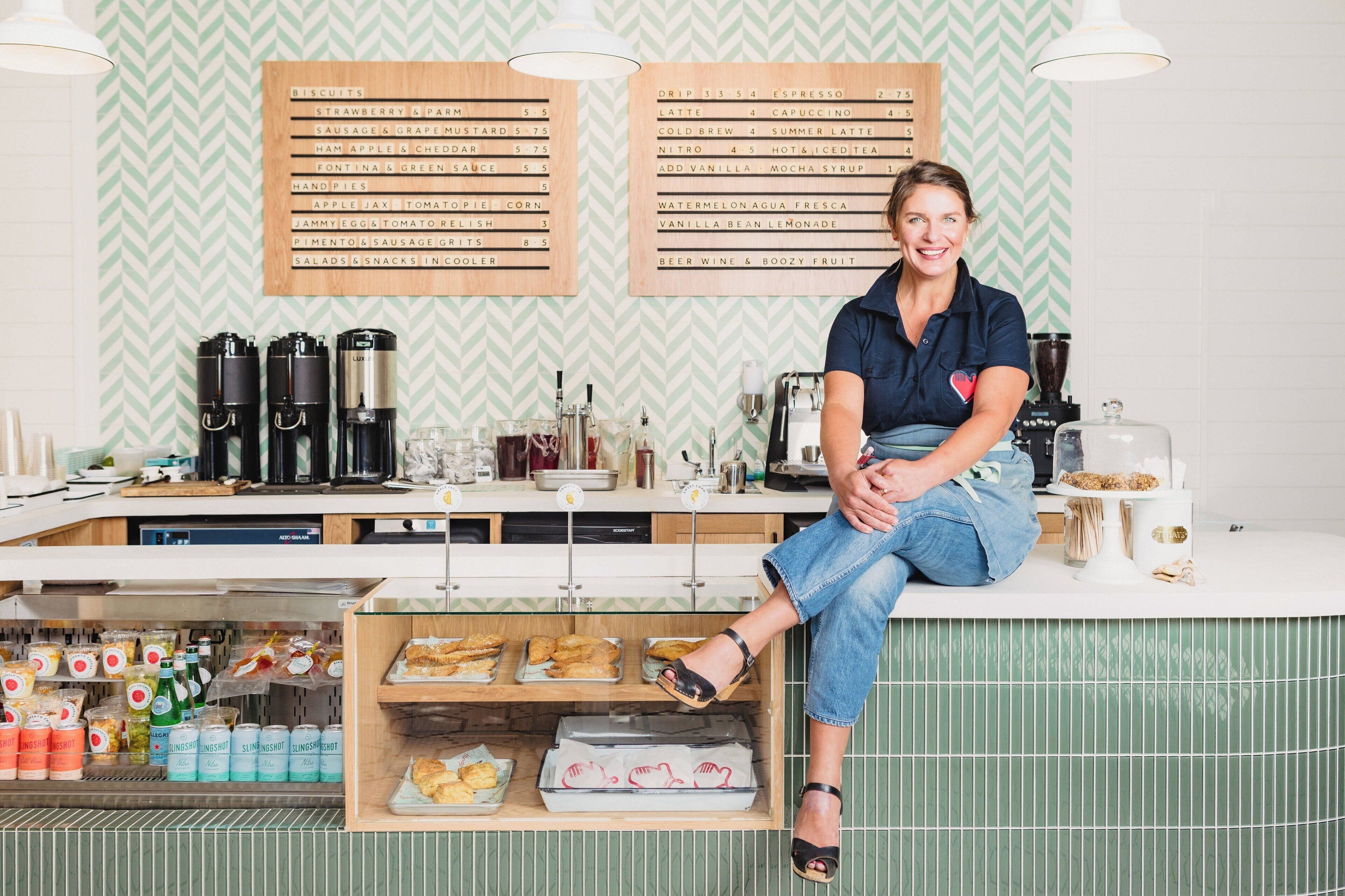 A person sitting at a counter with a menu board behind them.