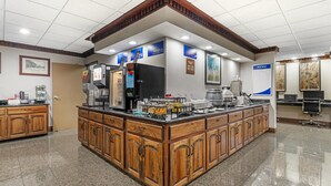 Eine Küchenzeile mit einem Büfett, einer Kaffeestation und einem Menüschild.