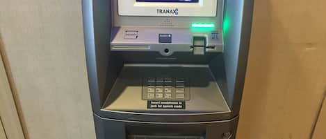 An ATM machine with a display screen, card reader, and cash dispenser.