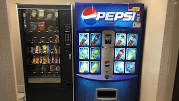 Two vending machines, one for Doritos and another for Pepsi, in a hallway.