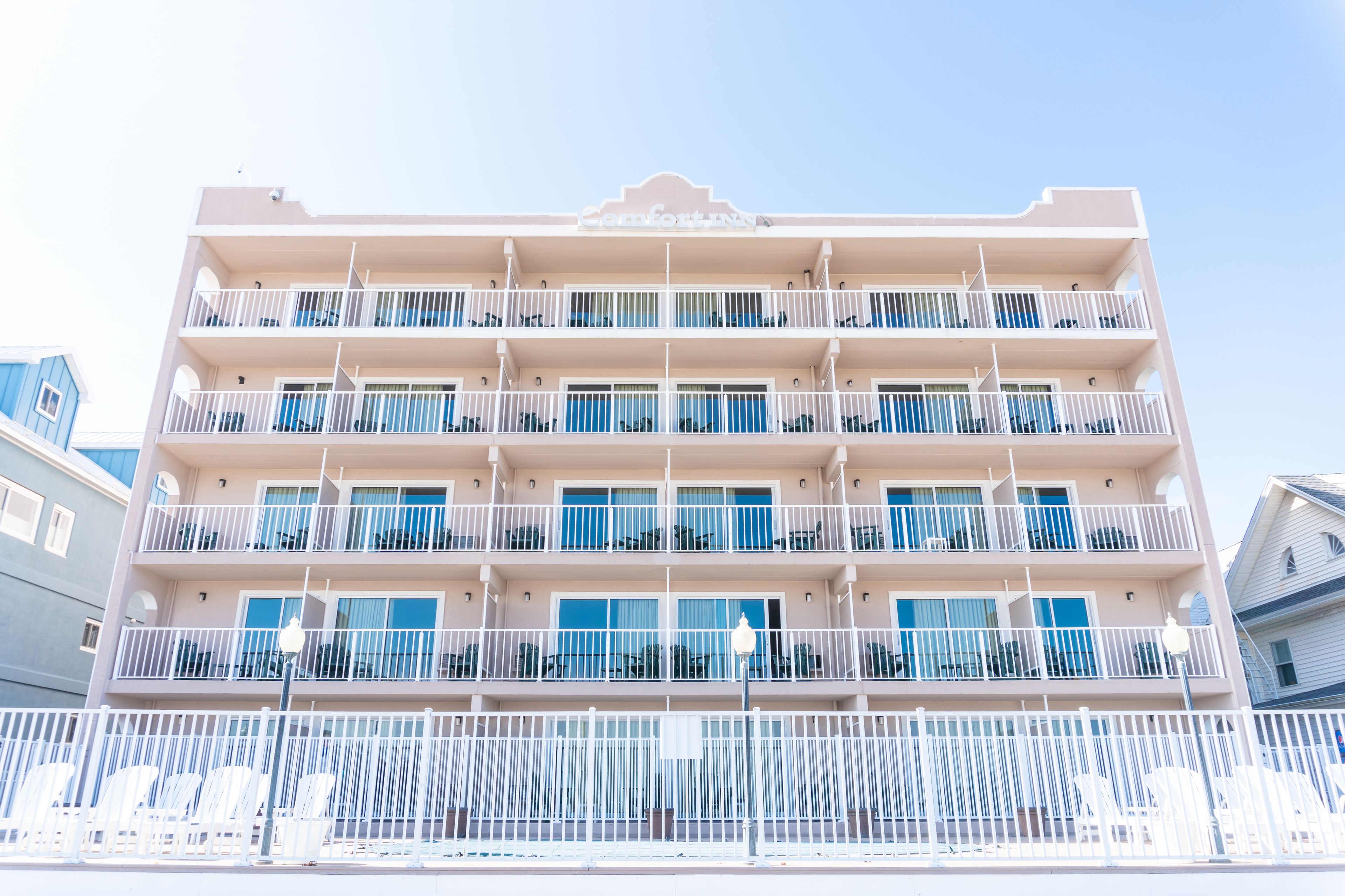 Un hotel de varios pisos con balcones, techo plano y fachada blanca.