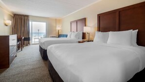 A hotel room with two beds, a desk, and a chair. There is a window with curtains, a lamp, and a nightstand with a phone. - Comfort Inn Ocean City Boardwalk (Ocean City)