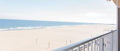 A beach view from a balcony with a clear sky.