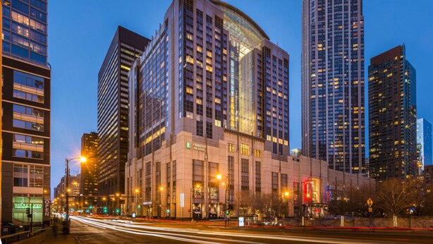 A hotel with a modern design, featuring a prominent curved glass facade and multiple floors. - Embassy Suites by Hilton Chicago Downtown Magnificent Mile (Chicago)