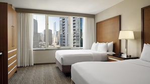 A hotel room with two beds, a large window with a city view, a wooden wardrobe, and a bedside table with a lamp. - Embassy Suites by Hilton Chicago Downtown Magnificent Mile (Chicago)