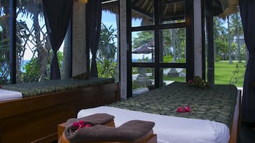 Relax in a serene room with a large bed, wooden bench, and lush garden views.