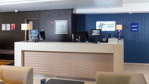 A hotel reception area with a modern design, featuring a reception desk, seating area, and a Holiday Inn Express sign. - Holiday Inn Express London Wandsworth by IHG (London)