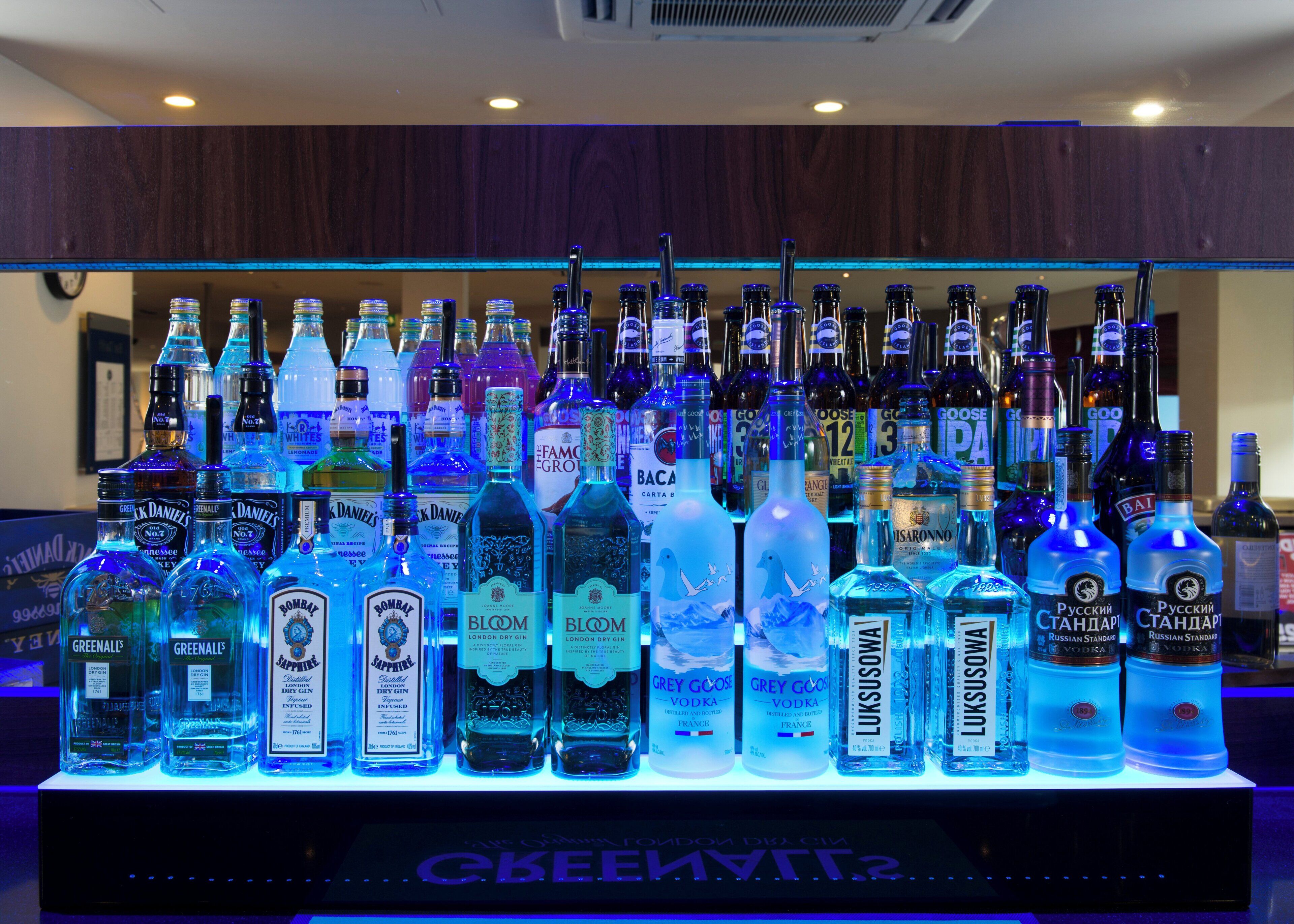 A bar area with a variety of liquor bottles displayed on shelves.