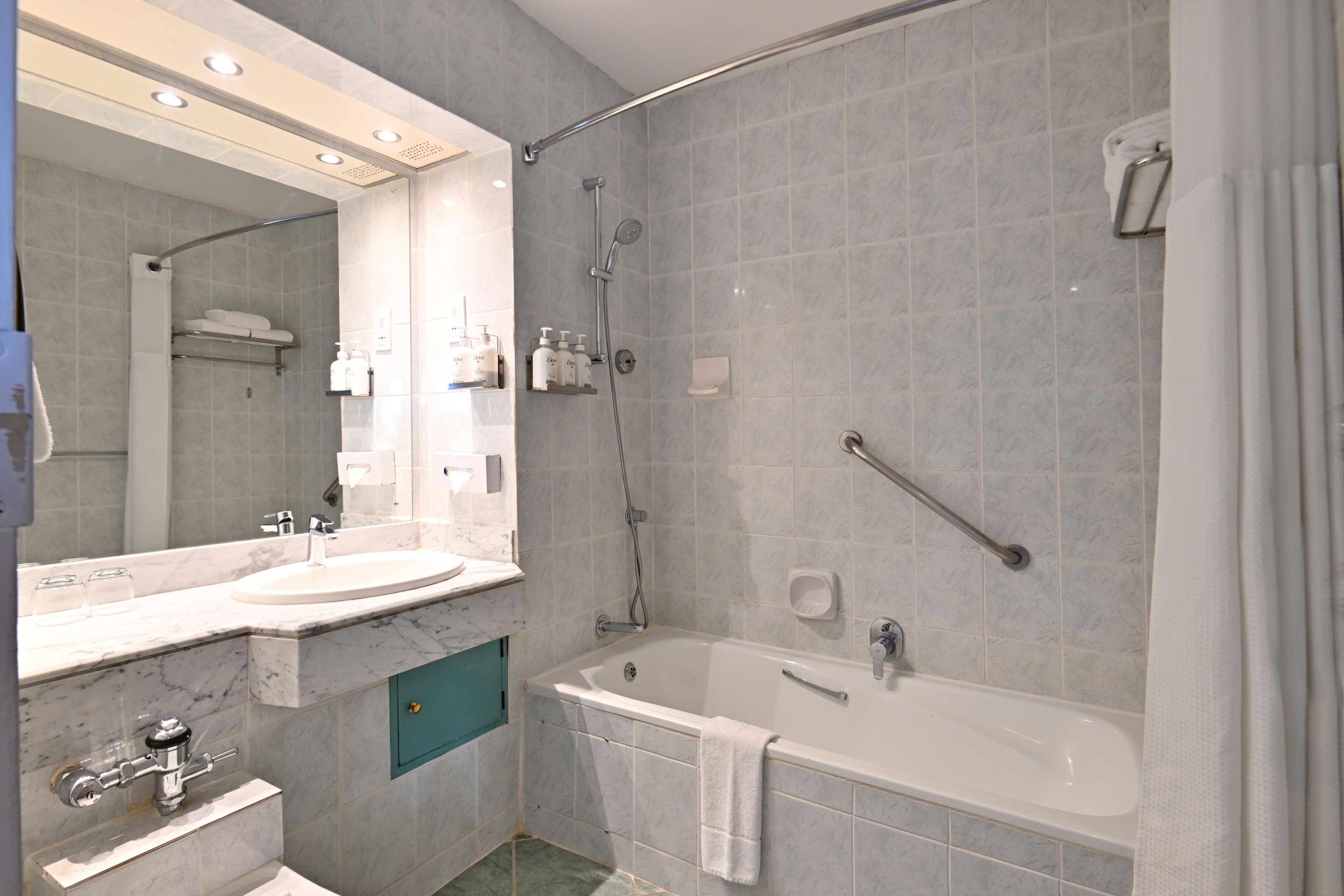 A bathroom with a sink, mirror, shower, and bathtub.