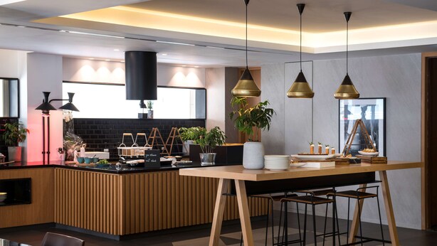 A modern kitchen with a wooden island, pendant lighting, and bar stools.