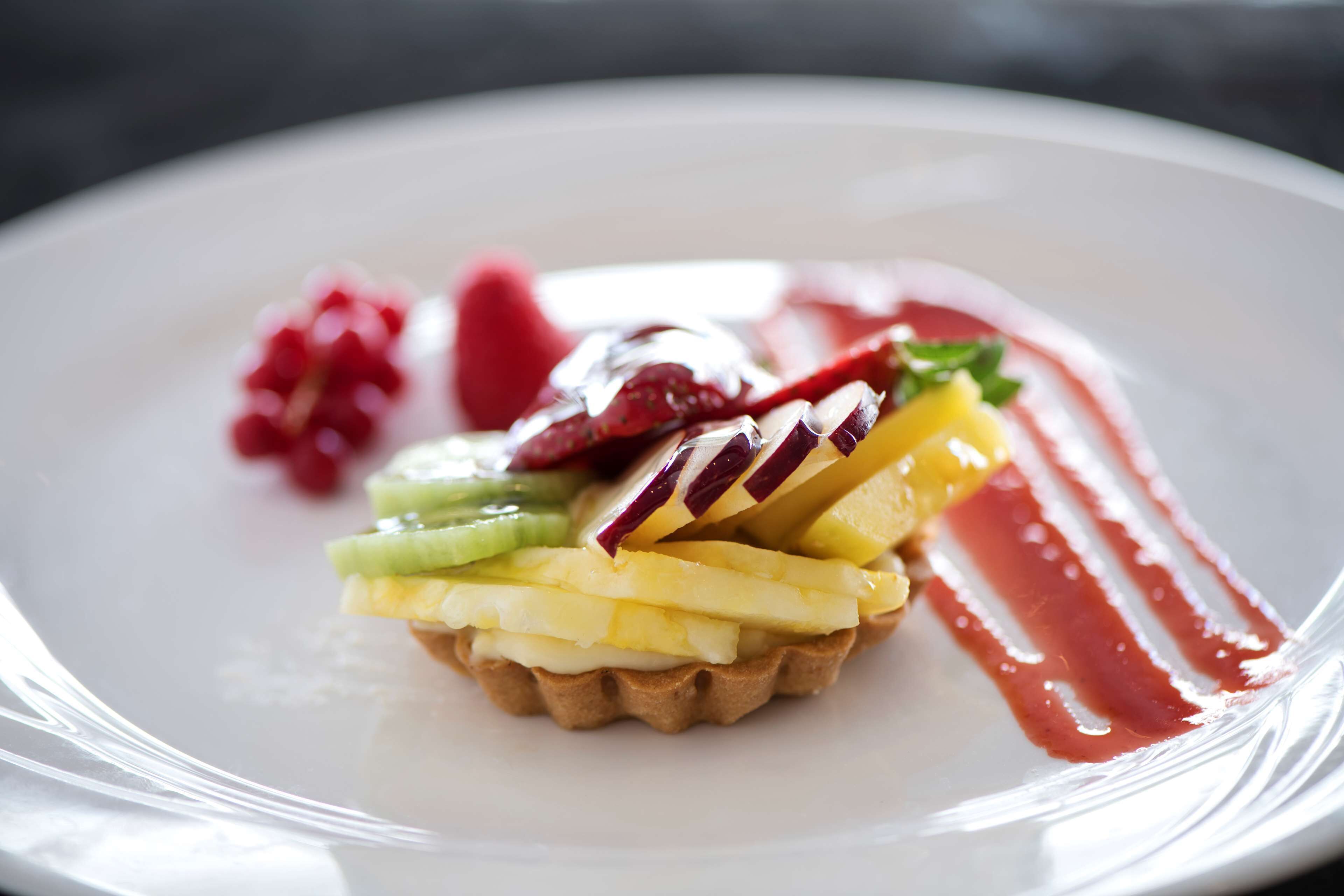 Un postre con fruta y salsa sobre un plato.