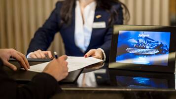 A reception desk with a laptop displaying a business program about a blue planet initiative.