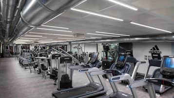 Un gimnasio con cintas de correr, elípticas y máquinas de pesas.