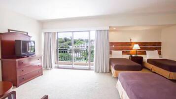 Habitación de hotel con cama, televisión, escritorio y vistas al exterior.