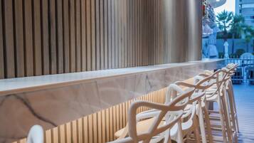 A row of white plastic chairs with a wooden slatted wall behind them.