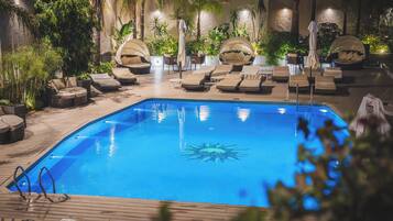 Una piscina al aire libre, tumbonas