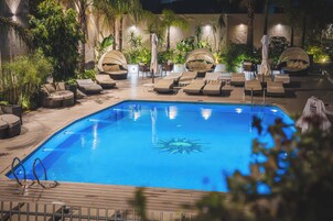 Una piscina al aire libre, sillones reclinables de piscina