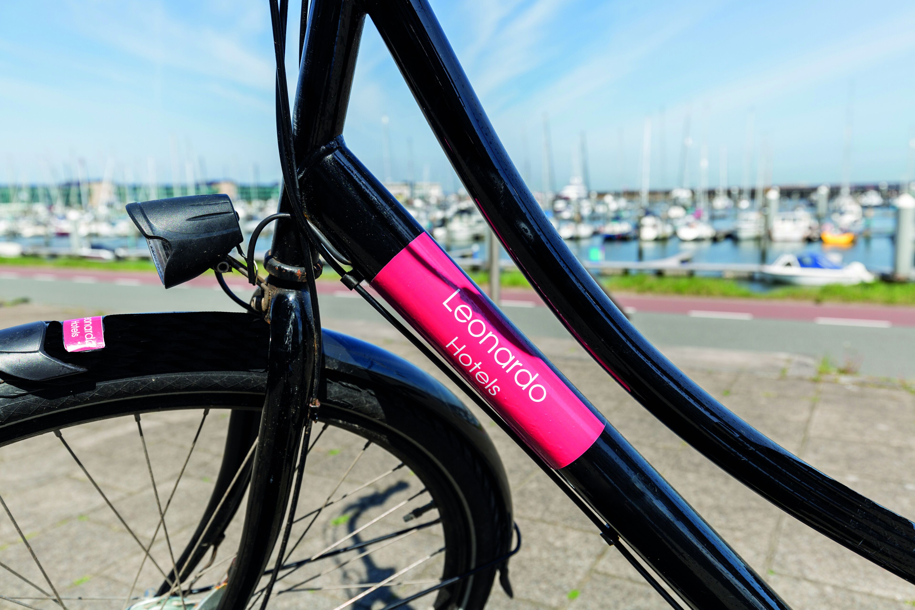 Una bicicleta con una etiqueta rosa que dice 'Leonardo Hotels'.