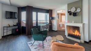 Una sala de estar moderna con chimenea, un televisor de pantalla plana y vistas a la ciudad.
