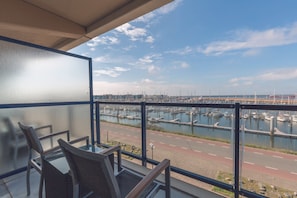 Un balcón con vista a un puerto deportivo y una carretera.