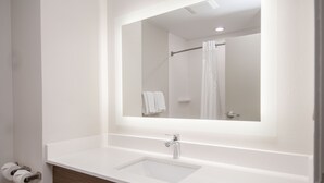A bathroom with a white sink, a mirror, and a shower curtain. - Holiday Inn Express & Suites Plano West - Frisco by IHG (Plano)