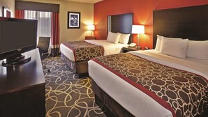 A hotel room with two beds, a TV, and a desk. - La Quinta Inn & Suites by Wyndham Elkview - Charleston NE (Elkview)